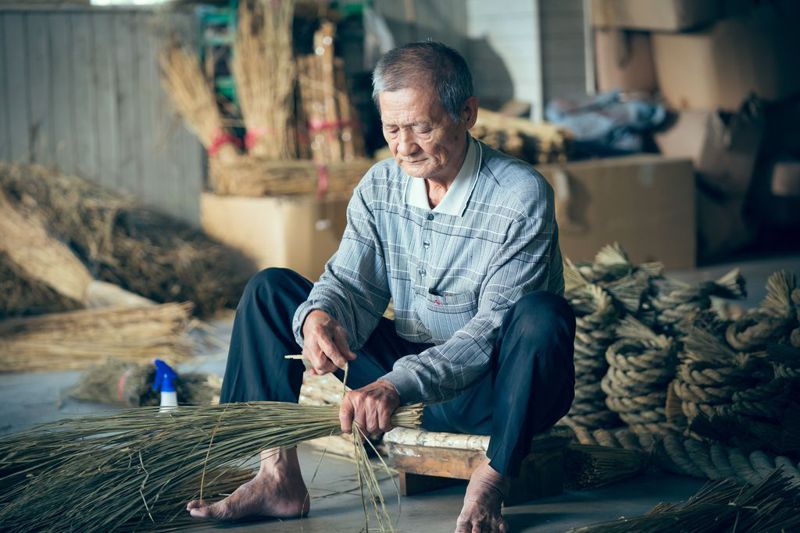 73歲草編師傅李龍日前由副總統賴清德頒贈「匠人魂」錦旗，毫不起眼的稻草到了他手上，就會出現千變萬化的姿態，成了各種藝術品。圖／文化總會提供