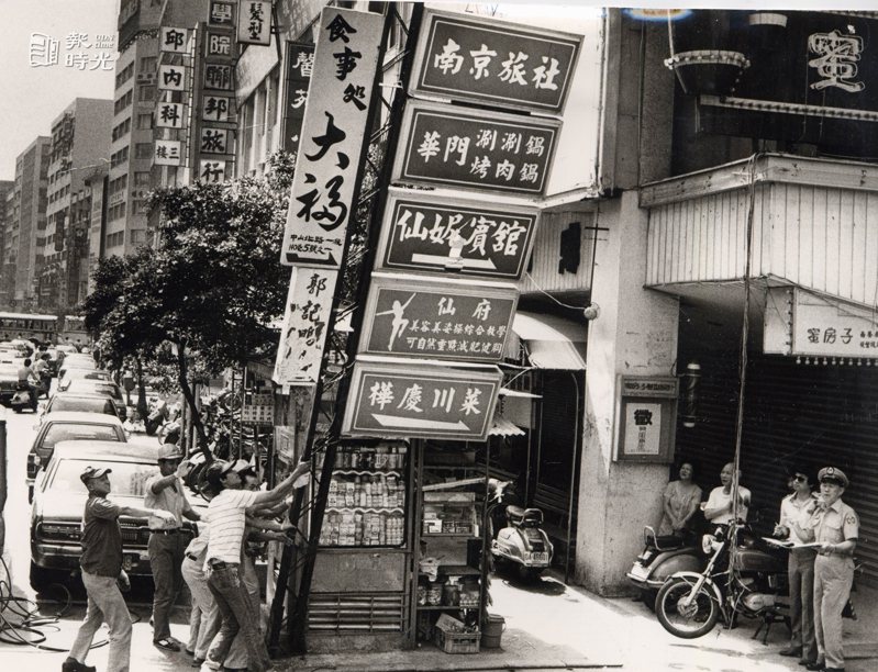 圖說：台北市警局整頓市容，昨起強制拆除違章廣告牌。昨天拆除的第一面違章廣告牌，位於南京西路新光百貨公司左側，上面共掛了七面廣告招牌。來源：聯合報。攝影：高鍵助。
日期：1983/06/10
