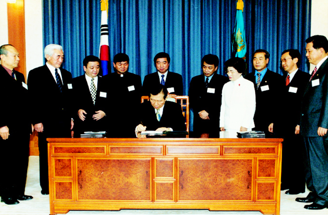 2000年1月，金大中（圖中）總統簽字的〈濟州四三事件真相調查及恢復遇難者名譽特...