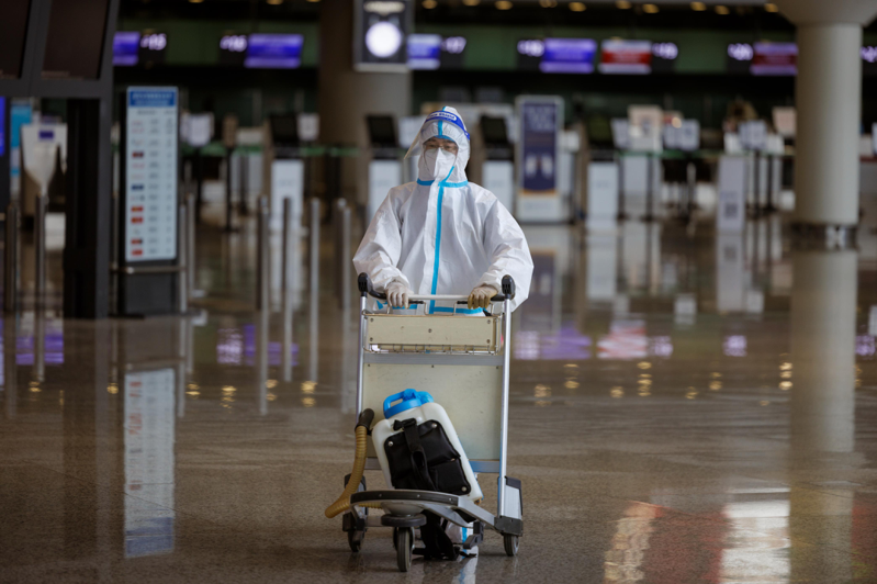 上海6月30日起放寬入境防疫規定。圖為上海虹橋機場29日一名身著全套防護裝備的旅客。歐新社