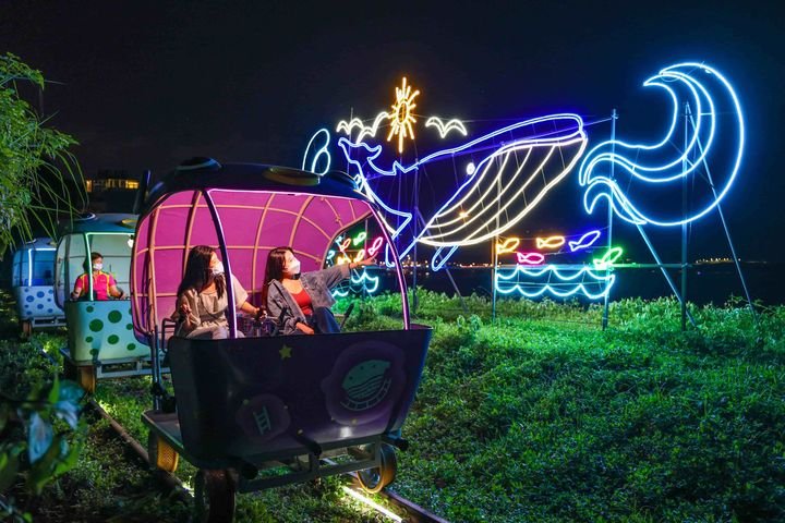 迎著海風騎乘鐵道自行車，各種璀璨燈飾閃耀迷人光輝。 圖／新北市政府觀光旅遊局提供