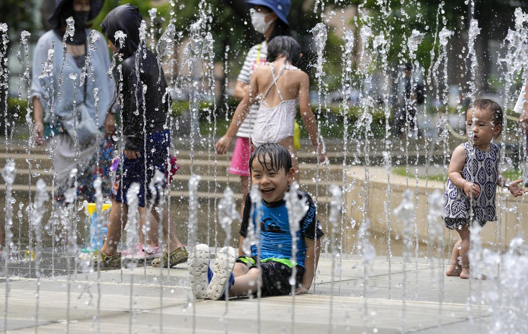 日本東京已連日出現「猛暑日」，孩童27日在當地公園噴泉戲水消暑。歐新社