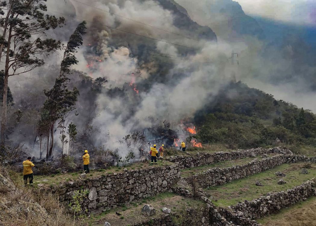 祕魯消防員6月30日正努力控制印加遺址「馬丘比丘」附近的森林大火，這座安地斯山脈...
