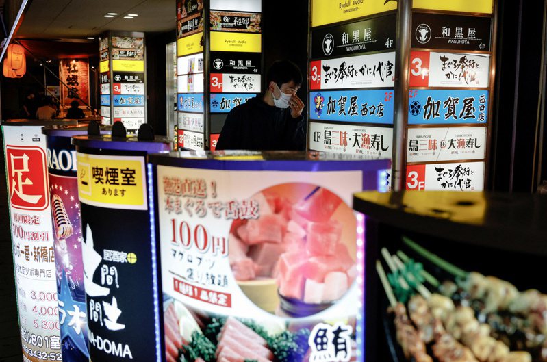 餐廳林立的日本街頭，人們透過美食評比網站選擇想去的店。路透