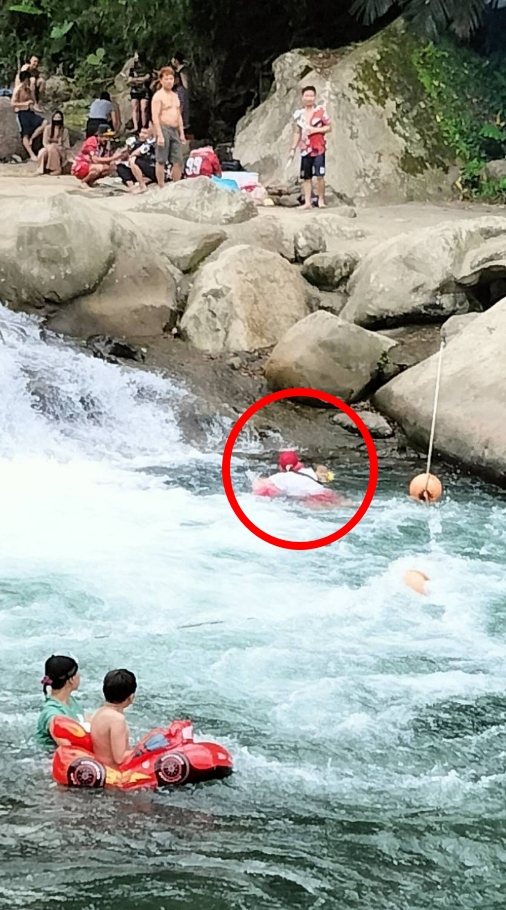 男童差點被捲進瀑布區，救生協會人員馬上跳入水中將男童帶出。圖／消防局提供