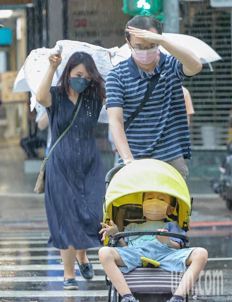 受西南風影響及午後熱對流發展旺盛，中央氣象局針對17縣市發布大雨、豪雨特報，台北地區下午下起大雨，未帶雨具的民眾躲避不及，只能用手或衣物擋雨。記者曾原信／攝影