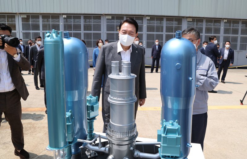 南韓總統尹錫悅（中）6月22日參觀慶尚南道昌原市的斗山能源公司，觀看南韓自行研發的新一代核電機組模型。（歐新社）