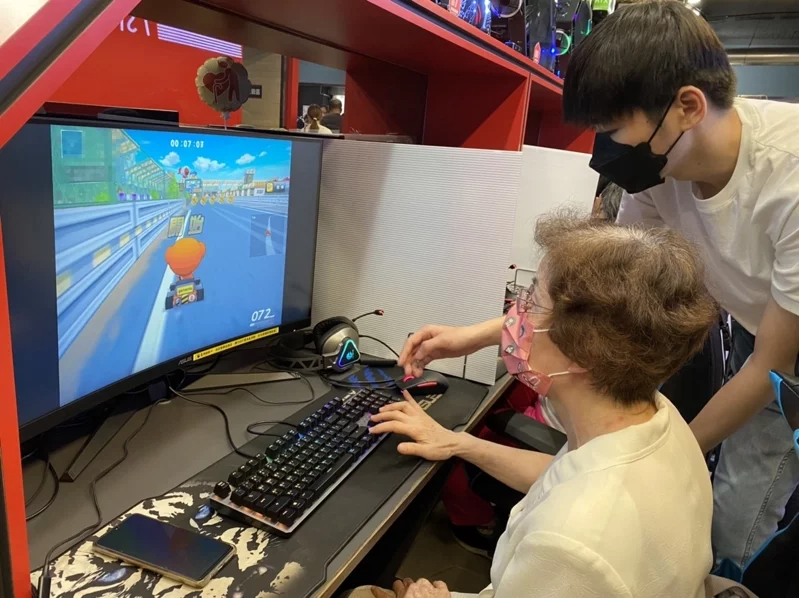 年紀最長80歲的黃阿敏(坐者)難掩興奮地說，她第一次玩電競遊戲，期待之後跟孫子有...