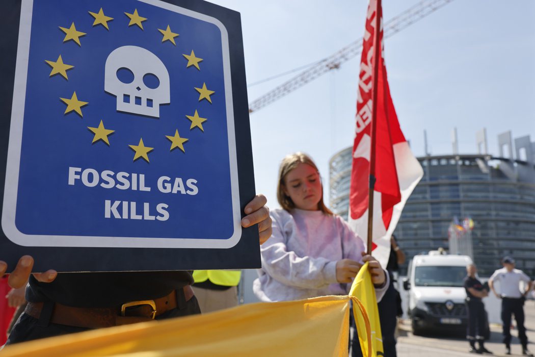氣候運動人士6日歐洲議會外抗議，手持繪有骷髏頭及寫著「化石燃料殺人」的標語。（美...