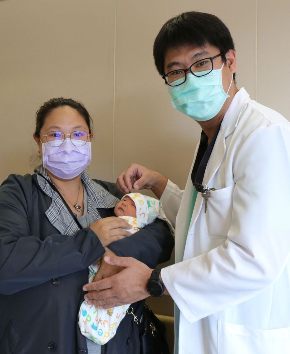 32歲染疫孕婦在亞大醫院順利產子，她在隔離期滿出院前抱子感謝醫護團隊。圖／亞大醫院提供