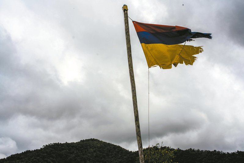 哥倫比亞發布最全面性的內戰真相調查報告，圖為內戰期間受損的國旗在叛軍陣營遭到倒掛的景象。（紐約時報）