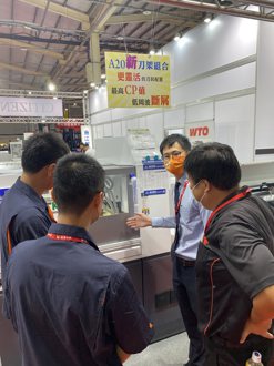  商江貿易副總陳信成（面對鏡頭），為到訪來賓介紹金屬切削新世代的機器功能。  吳青常／攝影