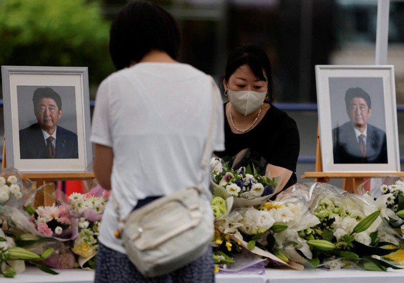圖為一名民眾獻花悼念已故日本前首相安倍晉三。路透