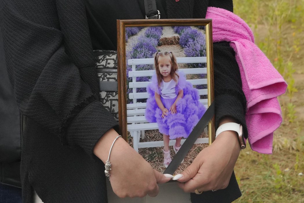 葬禮上，親友抱著麗薩生前的照片。 圖／美聯社　