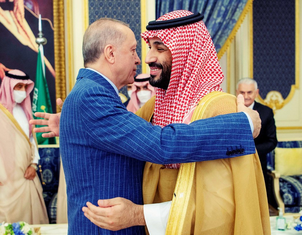 沙烏地王儲穆罕默德．本．沙爾曼，以他一臉雜毛的招牌咧嘴笑，伸出雙手擁抱了表情僵硬...