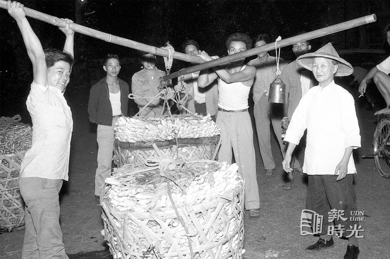 中央菜市場古稀老媼葉施妹，背著一桿大秤，在中央市場做蔬菜交易的持秤人。圖／聯合報系資料照（1958/09/01　陳明輝攝影）
