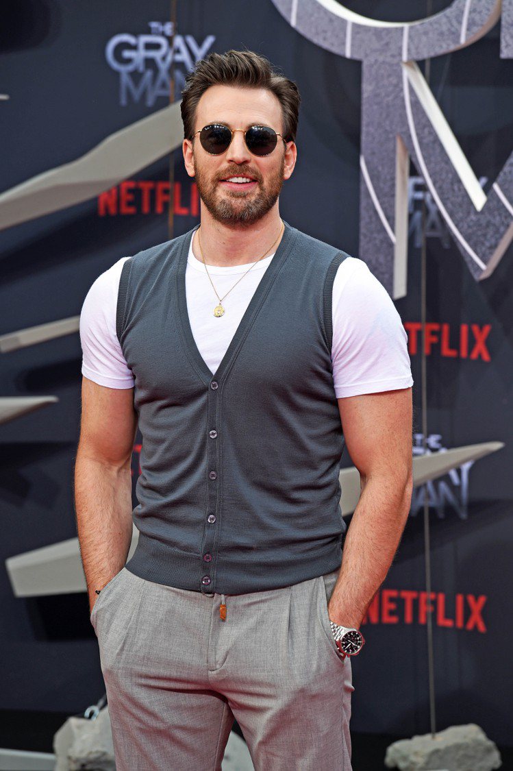 Chris Evans出席Netflix特映會時，以白T恤、灰色背心搭西裝長褲展...