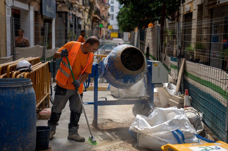 西班牙因热浪肆虐，一名清洁队员因为在中午高温下扫街活活热死，导致马德里市议会迅速通过提案，取消极端高温下午班清洁队员清扫服务。图为一名建筑工人在清理人行道。美联社(photo:UDN)