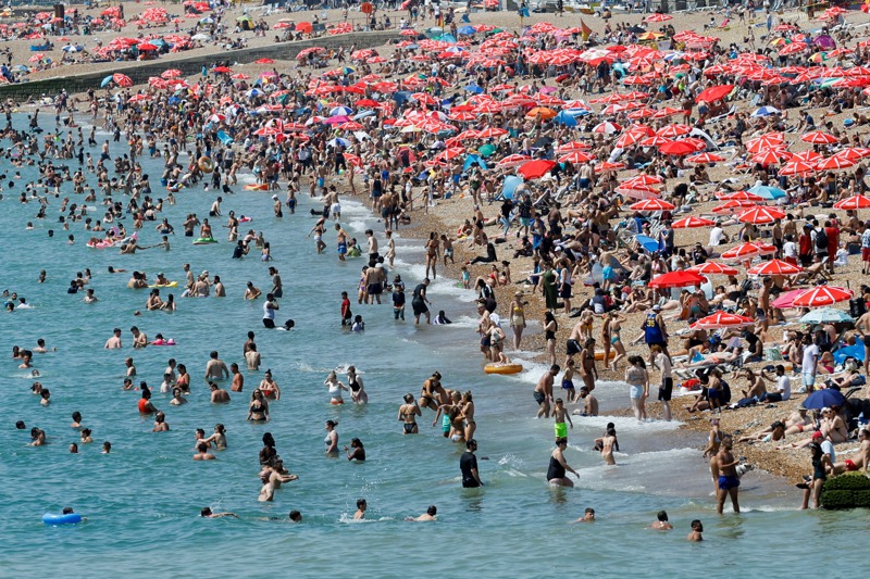 英國熱氣逼人，大批民眾19日湧入英格蘭布萊頓海灘玩水消暑。路透