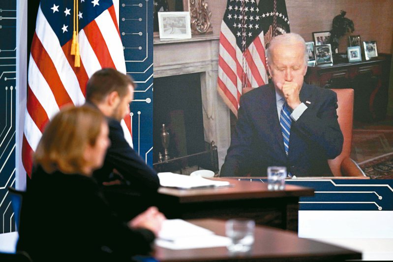 因確診新冠肺炎在白宮隔離的美國總統拜登（右），廿五日舉行視訊記者會時遮口咳嗽。（法新社）