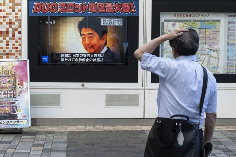 日本前首相安倍晉三遭槍擊消息傳出後，一位民眾8日在街頭駐足觀看新聞報導。法新社
