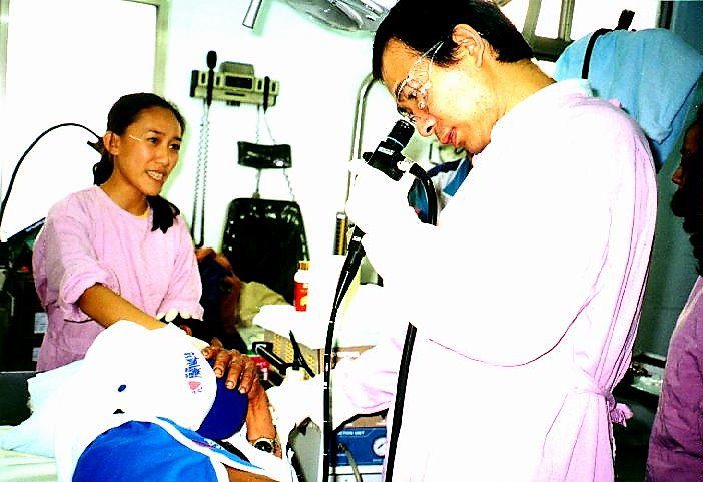 在醫療資源缺乏年代，白明忠(右)民國87年在蘭嶼為患者照胃鏡。圖／台東馬偕醫院提供