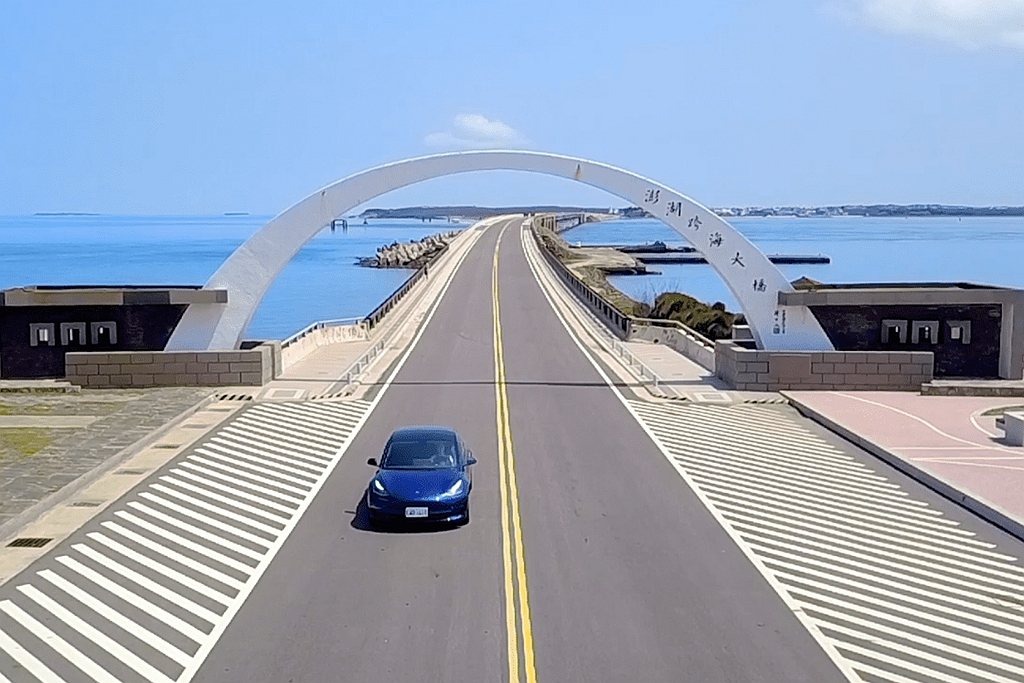 駕駛特斯拉電動車徜徉在澎湖跨海大橋，享受被蔚藍大海包覆的自在與暢快。 圖／特斯拉提供