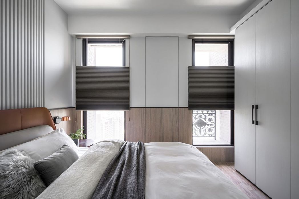 主臥床背造型延伸至窗戶立面，視覺風格一致並隱藏假柱儲藏櫃，維持整體風格。