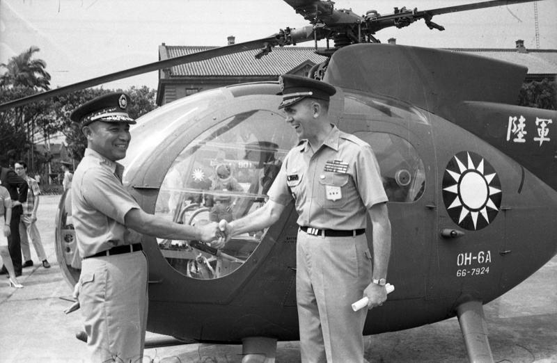 1969年首批美援OH-6A直昇機由美軍援華顧問團正式移交我國陸軍使用，美軍顧問團陸軍組長柯理福上校代表團長戚烈拉少將（右）與陸軍總司令于豪章上將（左）在直升機前握手交談。圖／聯合報系資料照片