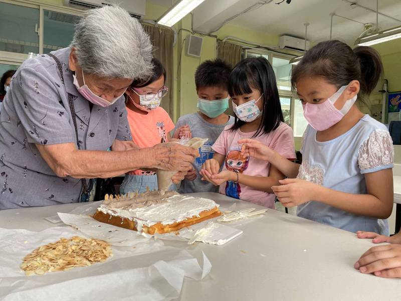 林口區樂齡學習中心92歲的學員張玉惠透過母親節活動，與瑞平國小學生一同製作蛋糕。圖／新北教育局提供
