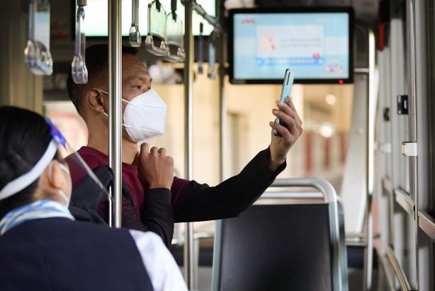上海一名乘客在登上公車時，按規定使用手機掃描公車「場所碼」。新華社