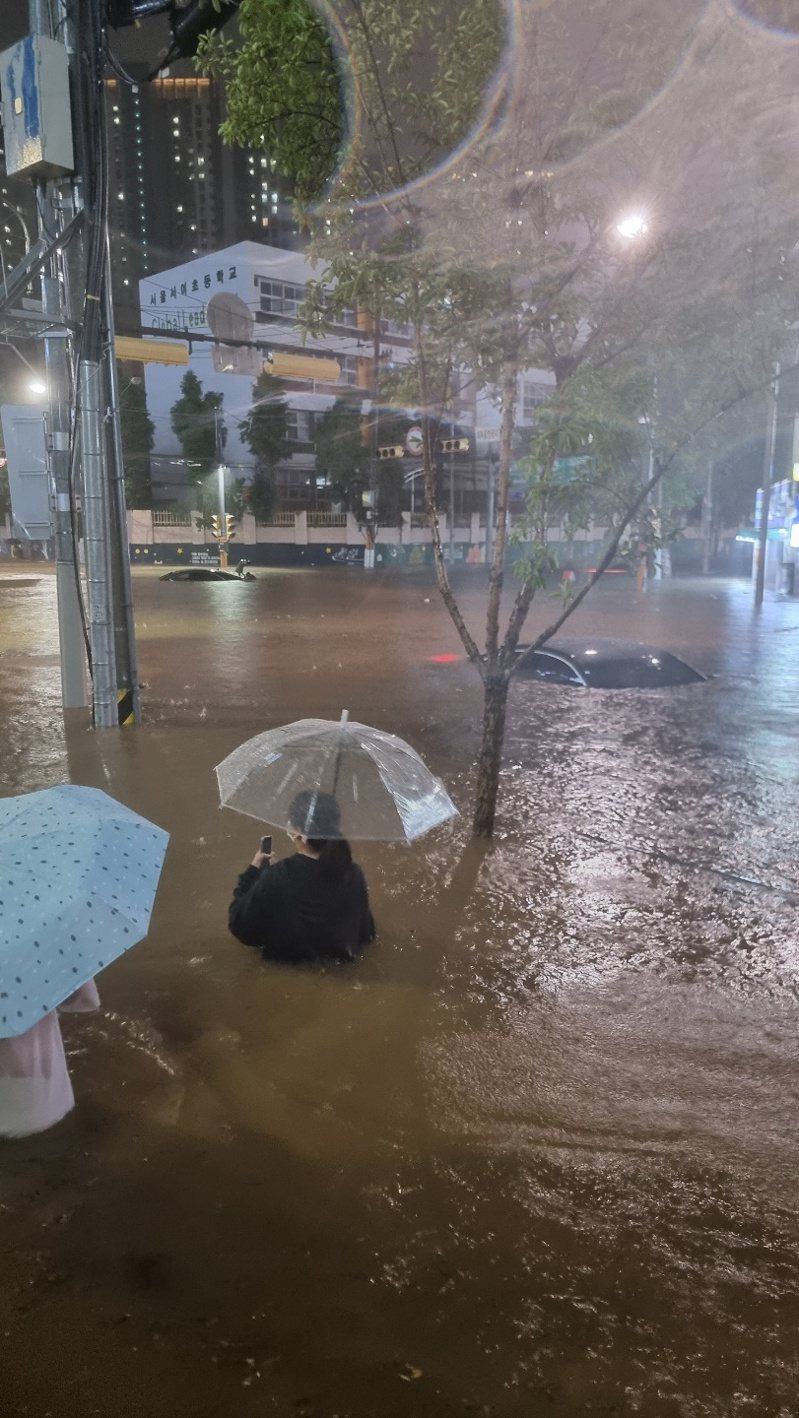 首爾8日晚間降下暴雨，部分地區水深過腰。圖／取自韓國先鋒報推特