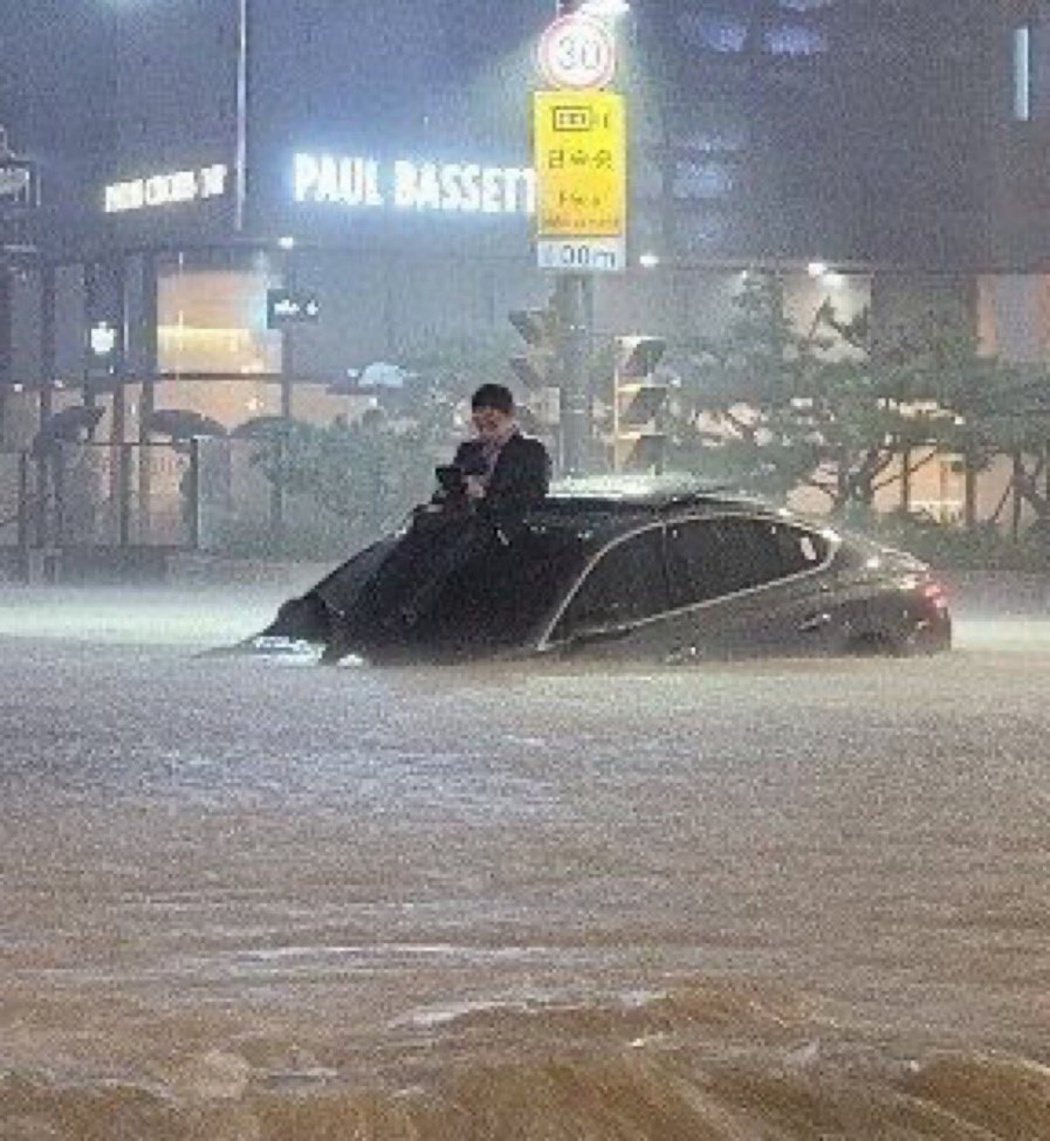 首爾市區一名男子受困車頂，不斷漲高的洪水幾乎要將他滅頂，照片在Twitter上瘋...