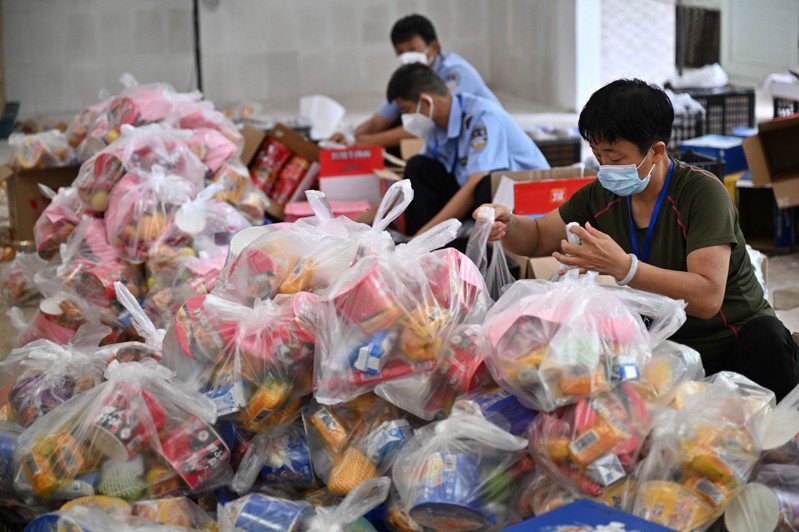 海南三亞爆發疫情，三亞工作人員將政府籌集的生活物資打包，準備送往遊客入住的酒店。（新華社）