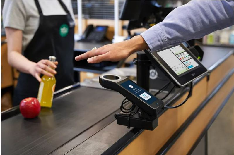 亞馬遜加州65家全食超市推出掌紋掃描支付服務，消費者到門市消費結帳便不必再掏出錢包或手機，只須在機台上攤開手掌就能付款。圖／擷自The Verge