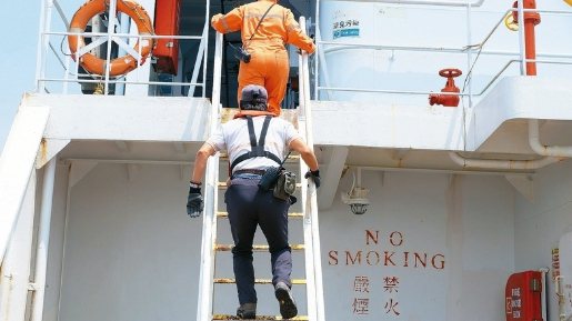 圖為引水人搭小船出海，爬梯上大船領港工作情形。本報資料照片