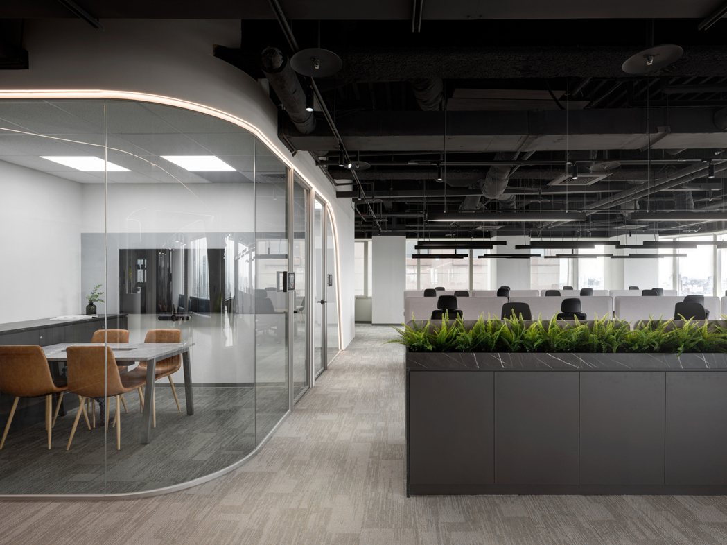 從入口區就可看見以弧形搭配光條構築的辦公室基調，增加空間的玩味之餘，也符合 IT...