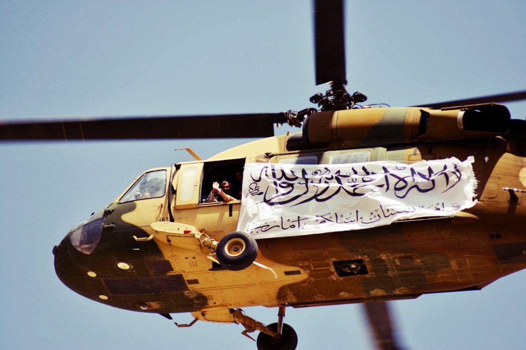 2021年9月1日——塔利班奪權半個月後——一架掛著塔利班旗幟的直升機飛躍上空，...