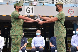 新加坡男性當完2年兵退伍後，每年都必須回營受訓，另須定期接受體能測試。圖為星國新兵授槍典禮。圖／新加坡國防部網站