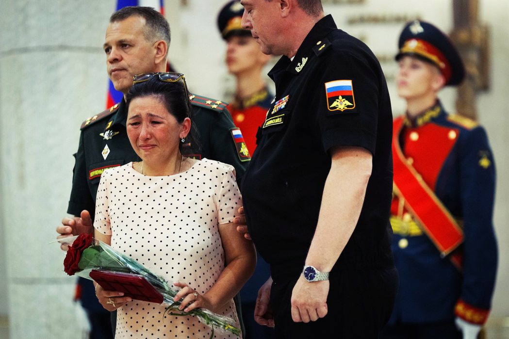  6月30日，俄羅斯當局向遇難家屬頒布勇氣勳章，一名遺孀在儀式上哭泣。 圖／美聯...