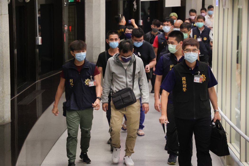 國人赴柬埔寨工作遭詐騙，台、泰警方聯手在泰國曼谷機場救出九名台灣人，檢方訊後發現其中一名何姓男子（中，著灰衣）是人蛇集團成員，向法院聲請羈押。 圖／聯合報系資料照片