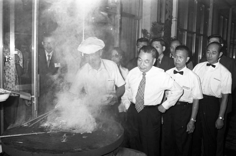 1973年8月20日，時任行政院長蔣經國（右三）與國家建設研究會與會人員聚餐，蔣經國觀看大廚炒蒙古烤肉。圖／聯合報系資料照片