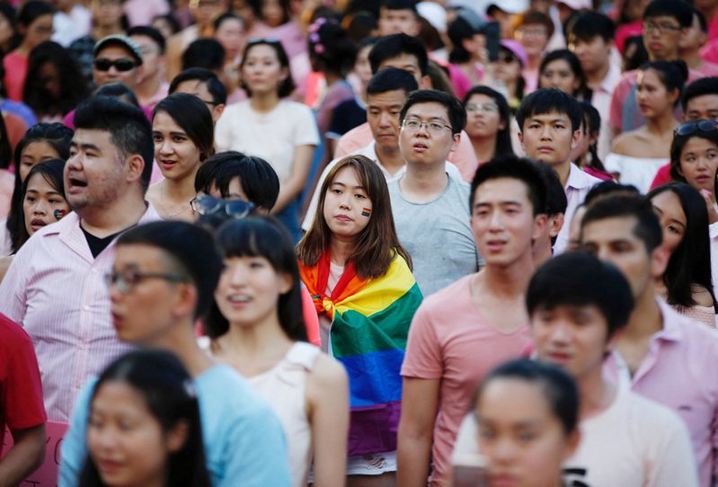 新加坡一名女子2017年7月披著彩虹旗參加每年聲援同性戀、雙性戀和跨性別戀愛自由的「粉紅點」活動。路透