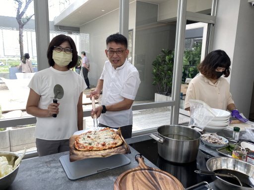 磐興建設總經理游金洲（中）打造「娘家館」，與妻子（左）、員工等一起料理、烤披薩，...