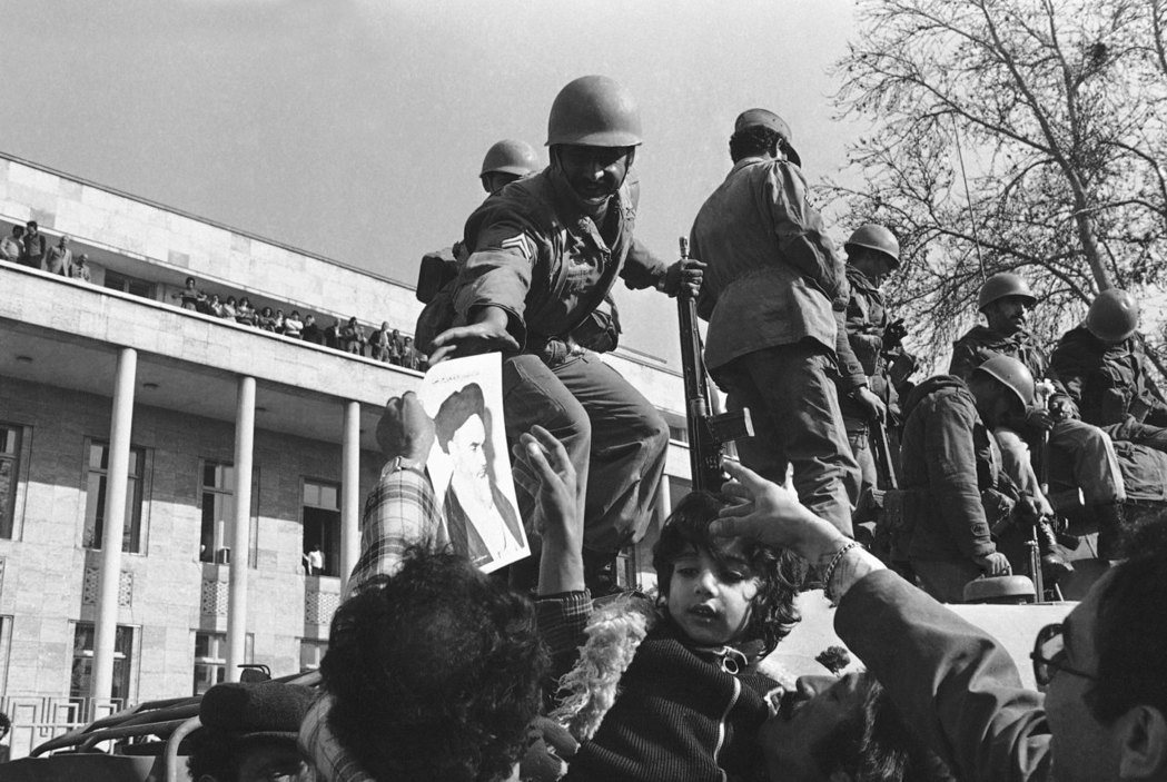 1979年1月伊斯蘭革命之後，何梅尼走向最高權力。圖為革命期間，伊朗士兵從民眾手...