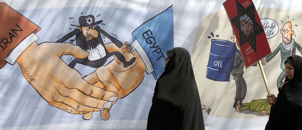 伊朗婦女在何梅尼發起的「耶路撒冷日」觀看批判以色列的漫畫壁畫。 圖／法新社　