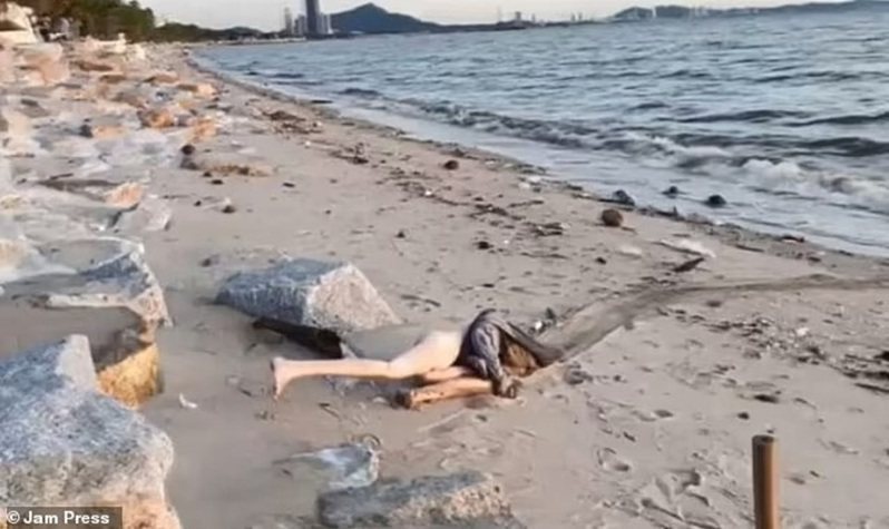 泰国春武里府邦盛海滩日前发现了一具「尸体」，可见一只长腿就裸露在外，看上去就像陈尸海滩的裸女只用T恤盖住头部，事后才发现是一个超逼真性爱娃娃。画面翻摄：MAILONLINE(photo:UDN)