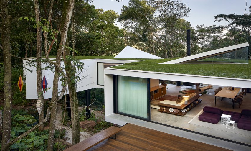 樹屋的屋頂上鋪設綠色草皮，使這棟白色建築量體與自然景色巧妙融合。