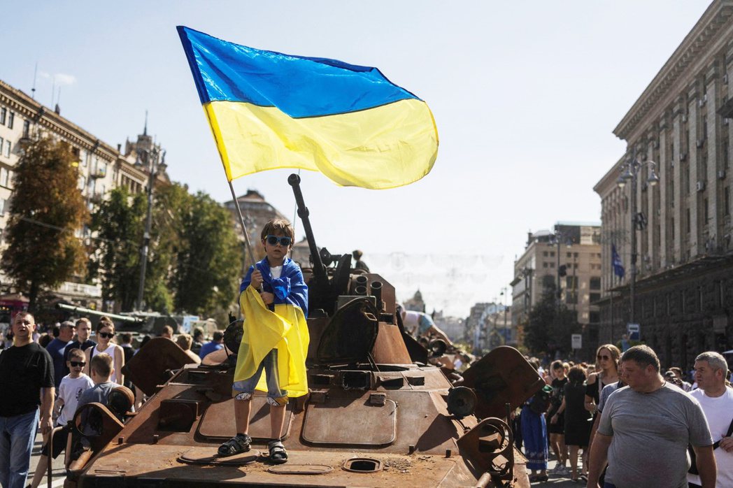 8月21日，一名烏克蘭男孩在基輔市中心，毀損的俄軍坦克上揮舞烏克蘭國旗，慶祝即將...