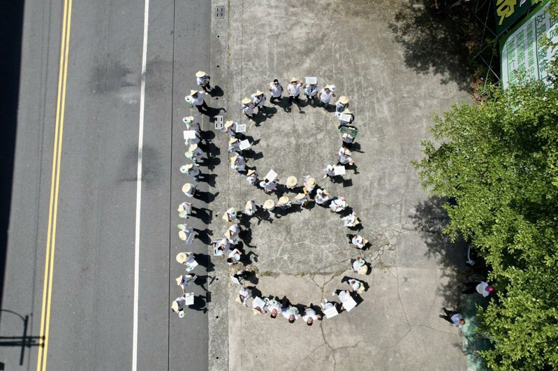 台南市立委王定宇等人今天邀集支持者與年輕人，在烈日下排出「18」字樣，來表達推動的決心。圖／王定宇服務處提供